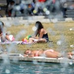 People relax by a pool at Marble Arch, in central London
